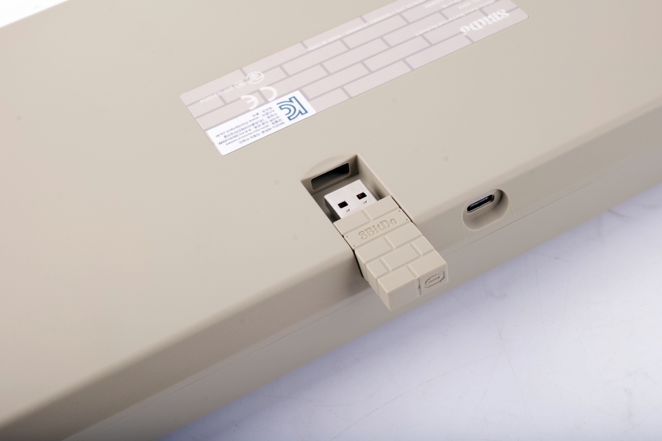 8BitDo 키보드 C64는 고전 게임이 연상되는 귀여운 벽돌 모양의 2.4GHz 무선 동글을 제공한다.